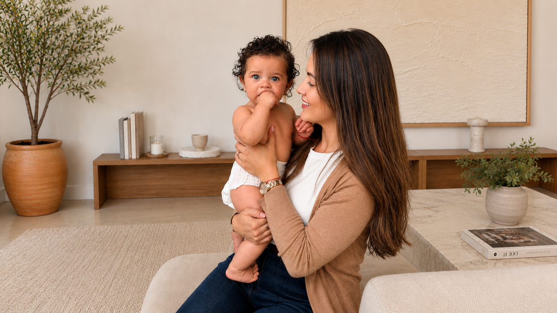 Mother holding and kissing her baby at home.